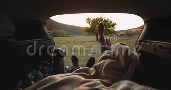 一对夫妇带着一辆车旅行他们停下来躺在后备箱里有一双舒适的袜子和一个大热水瓶视频的预览图