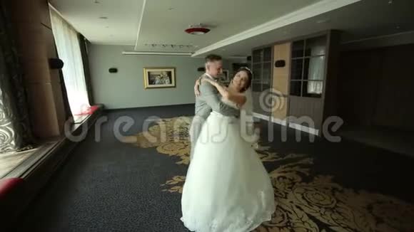 新婚快乐的新婚夫妇在一个房间里跳华尔兹在一个酒店里有一个美丽的内部视频的预览图