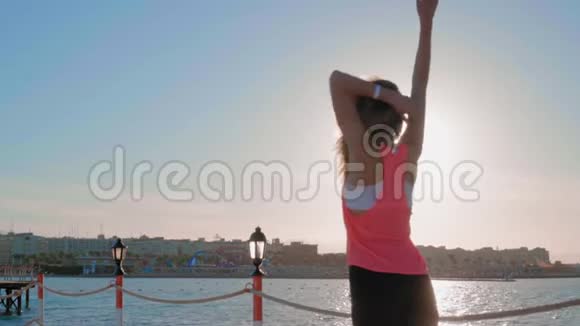 一个年轻的女孩在日落时沿着大海奔跑视频的预览图
