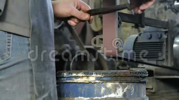 在皮带研磨机上研磨金属刀的坯料男人的手特写视频的预览图