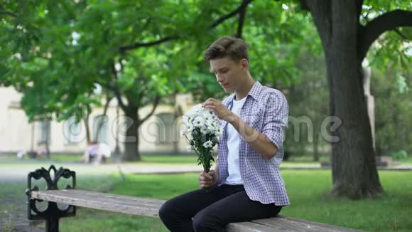 紧张的青少年等待女朋友带着鲜花留下花束失败的约会视频的预览图