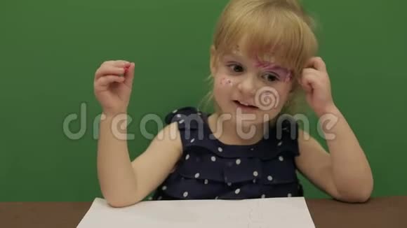 女孩在桌子边画画教育进程那个女孩有个好主意快乐的三岁女孩可爱的女孩微笑视频的预览图