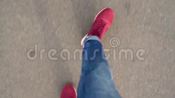 男子穿着红色运动鞋柏油路上行走的俯视图视频的预览图
