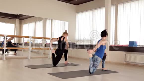 女孩在有氧运动课上微笑着做运动健身教练在健身房和一个女孩合作视频的预览图