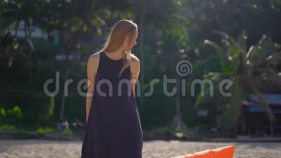 一位年轻女子坐在一张充气沙发上的热带海滩上的慢镜头暑假概念视频的预览图