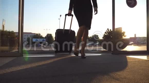 商务小姐带着行李去机场穿着高跟鞋的年轻女子穿过玻璃门走到视频的预览图