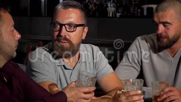一群成熟的男性朋友在酒吧里用一杯威士忌谈笑风生视频的预览图