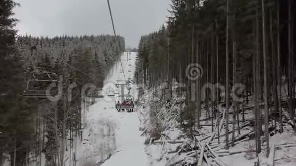 快乐的游客在斯洛莫冬季在喀尔巴阡山的一个长长的滑雪缆车上行走视频的预览图