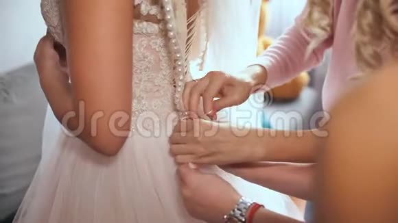 新娘女朋友帮新娘穿上婚纱视频的预览图