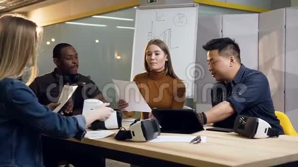 年轻人一边拿文件一边坐在桌边视频的预览图