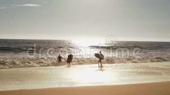 家庭经营海洋冲浪板年轻家庭经营海滩到海洋携带身体板视频的预览图