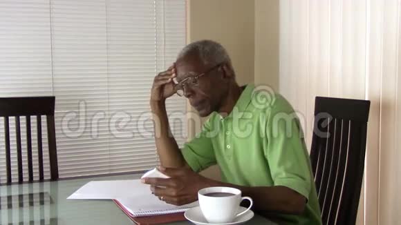一个不幸的老人用计算器计算他的财务状况视频的预览图