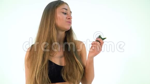 可爱的金发女人在白色背景下吃黄瓜视频的预览图