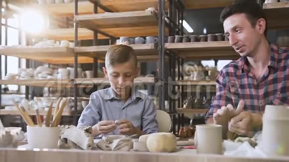 可爱的白种人男孩和他的父亲在陶器中制作陶罐视频的预览图
