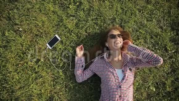 女孩在草地上听音乐视频的预览图