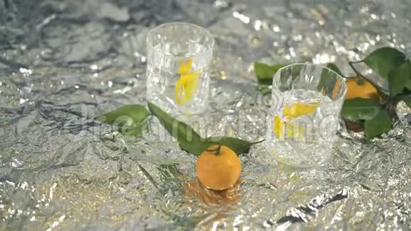 两杯鸡尾酒桌上放着柠檬和曼陀罗用闪烁的箔纸视频的预览图