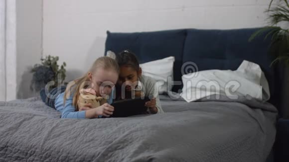 青少年女孩在家玩平板电脑的多样性视频的预览图