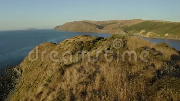 日落时的新西兰山丘环绕徒步旅行地点的空中平底锅视频的预览图