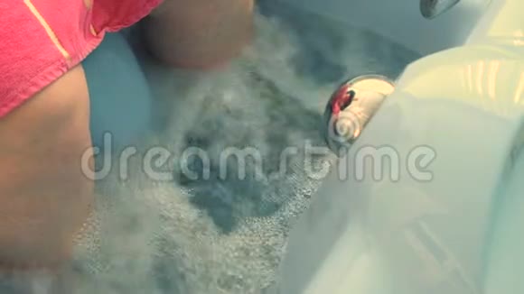 一个上了年纪的女人用水洗澡的腿特写镜头下肢积水医疗治疗视频的预览图
