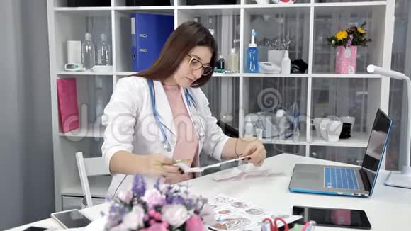年轻的女医生坐在她的办公室里检索测试结果视频的预览图