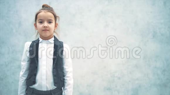 白色背景特写的可爱小女商人的肖像灰色背景的小女孩在此期间视频的预览图