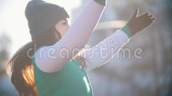 年轻漂亮的女人正在深秋公园热身跳跃慢动作视频的预览图