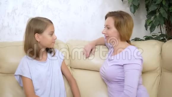 沟通观念妈妈和女儿母女俩在客厅的沙发上聊天玩得很开心视频的预览图