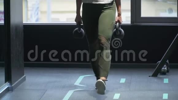 不可辨认的女人在健身馆里用两个重量做台阶美丽女人的健康生活方式身体视频的预览图