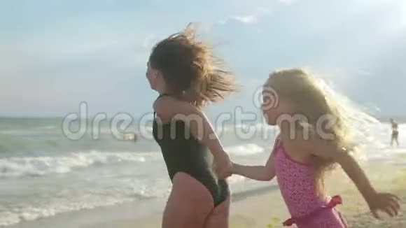 妈妈和女儿沿着海滩逃到海里游泳视频的预览图