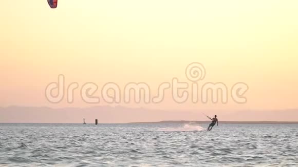 年轻人在海里风筝冲浪泼水五颜六色的日落视频的预览图