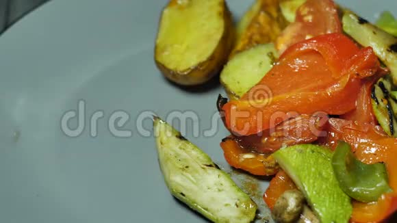 黑手套厨师形成一盘什锦肉放在烤蔬菜和土豆的盘子里视频的预览图