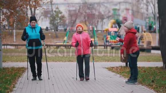 一位幸福的老年妇女发出手势两位老年妇女开始用北欧的拐杖走路视频的预览图