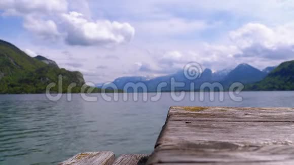 山湖和雪山阿尔卑斯山背景上的木制码头奥地利沃尔夫冈湖视频的预览图