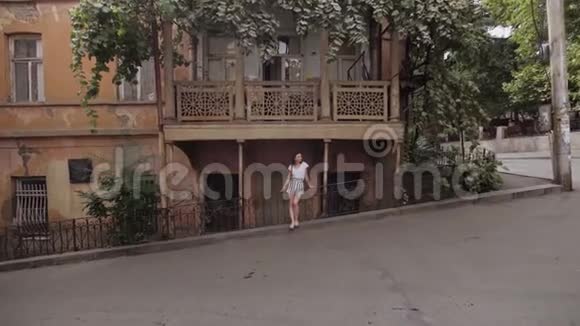 女孩欣赏格鲁吉亚第比利斯街道的景色城市老城区典型建筑视频的预览图
