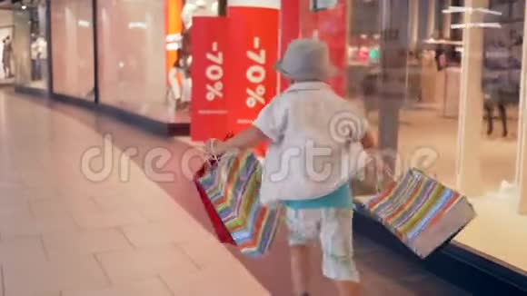 秋季销售时尚儿童带着购物袋在精品店里匆忙打折视频的预览图