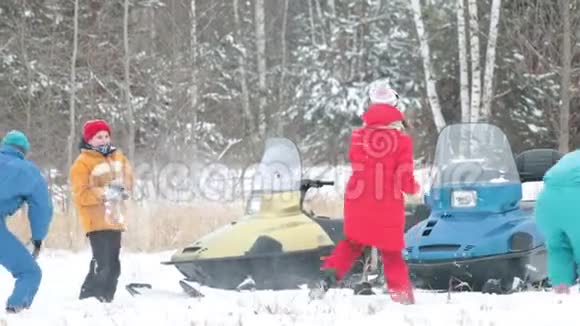一家人在森林里一辆雪车附近的雪地里玩耍视频的预览图