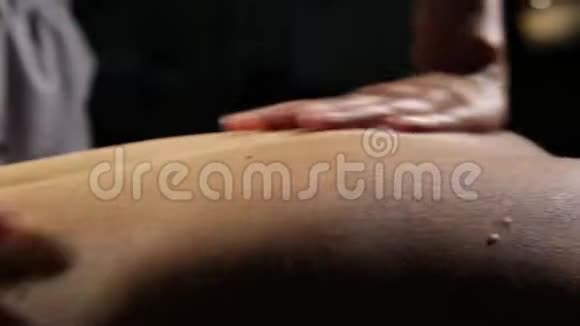 水疗沙龙的特写背部按摩按摩治疗师对女性身体做经典按摩视频的预览图