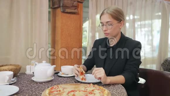 年轻女子坐在咖啡馆里享受着披萨视频的预览图