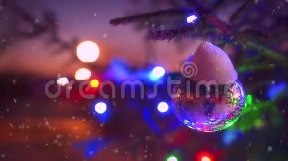 圣诞树的近枝上闪烁着五颜六色的灯光周围环绕着飘落的雪视频的预览图