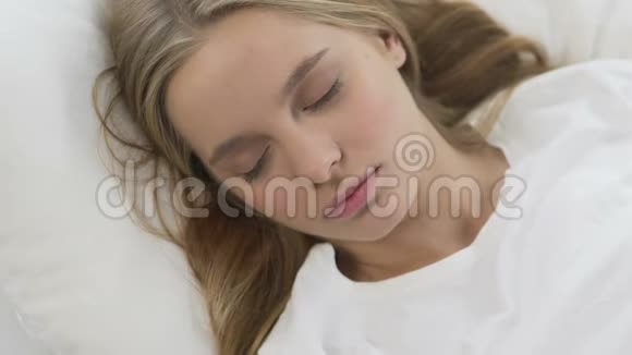 可爱的女孩舒适地睡在柔软的床单上平静而安静的梦景视频的预览图