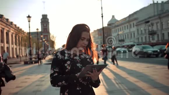 年轻迷人的汉索美少女在城市街道上使用平板电脑上网视频的预览图