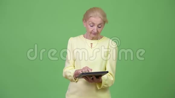 漂亮的高级女商人用数码平板电脑思考视频的预览图