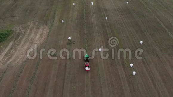 农业机械将作物卷成捆包起来用白色包装空中观景4K视频的预览图
