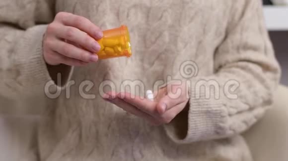 女人吃维他命女人把药丸倒进手掌视频的预览图