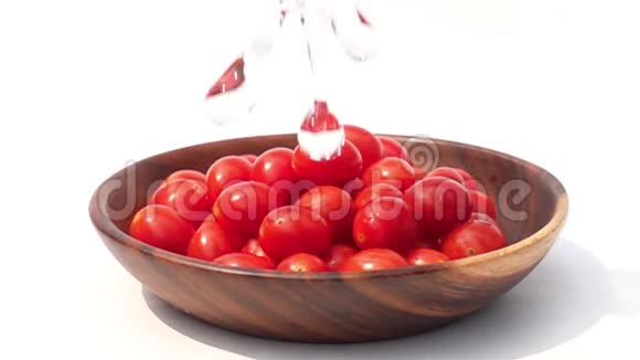 在白色背景下向一堆樱桃番茄浇水视频的预览图