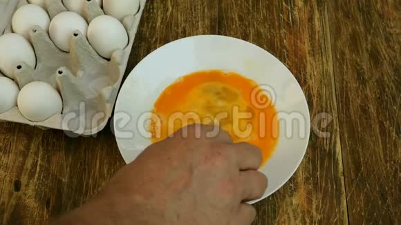 自制厨房厨师的手打着用叉子把碎鸡蛋混合在一个白色的盘子里视频的预览图