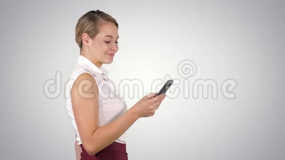一半长的照片年轻女商人看她的手机阿尔法频道视频的预览图