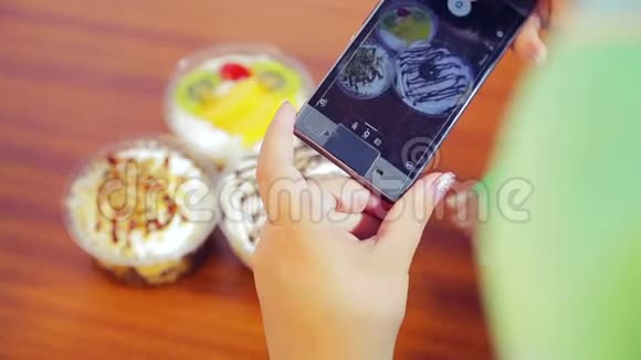 女性手拿着手机拍蛋糕视频的预览图