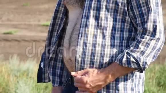 一个农夫站在田里一个穿格子衬衫的男人的大毛肚视频的预览图