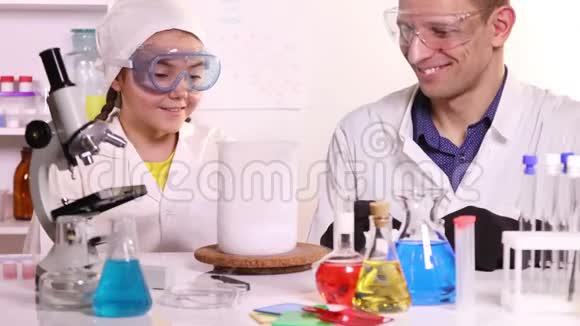 一位年轻的科学家为一名女学生上化学课视频的预览图